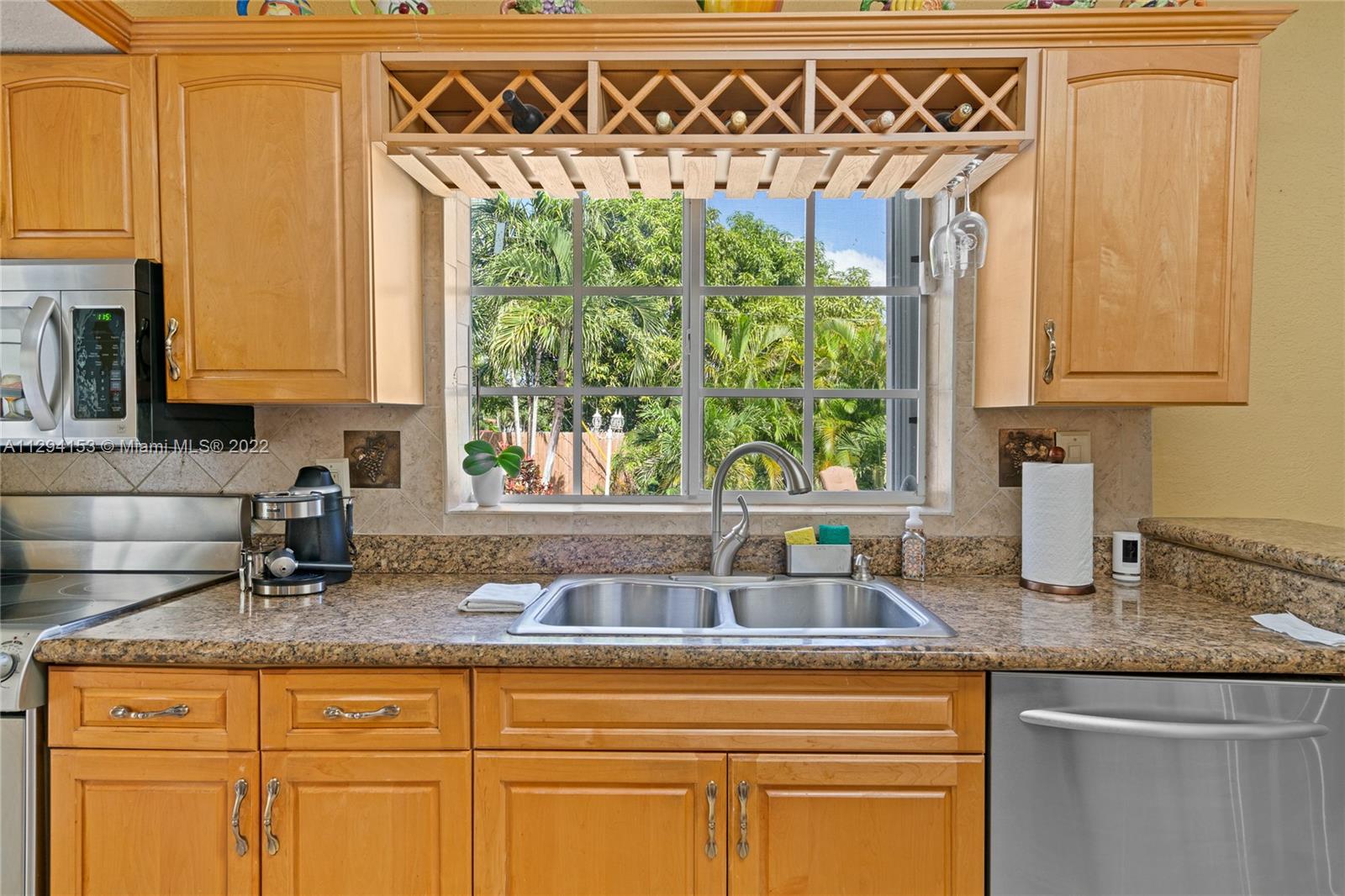 9901 Southwest 35th Terrace Miami, FL 33165 - Photo 33 of 50 a kitchen with stainless steel appliances granite countertop a sink a window and a counter space