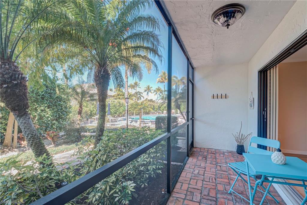 1070 6th Street South, Unit 1070 Naples, FL 34102 - Photo 18 of 41 Screened-in patio lanai space with access to the pathway to the pool, carport, guest parking. Towel holder, 2 bike hooks, and a fan compliment this space.