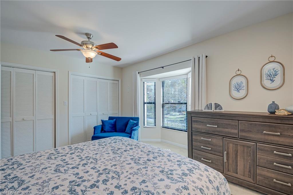 1070 6th Street South, Unit 1070 Naples, FL 34102 - Photo 26 of 41 Bedroom with multiple closets, ceiling fan, and light colored carpet