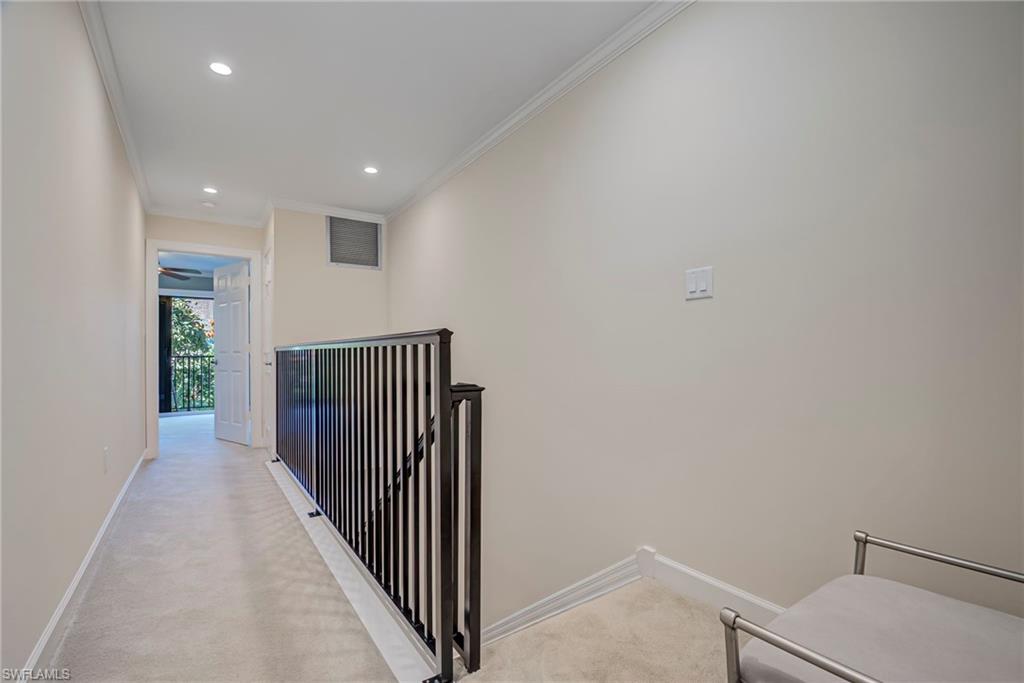 1070 6th Street South, Unit 1070 Naples, FL 34102 - Photo 28 of 41 Hall featuring ornamental molding, recessed lighting, and light colored carpet. There is a landing area at the top of the stairs with a decorative bench. The hallway divides the two bedrooms.
