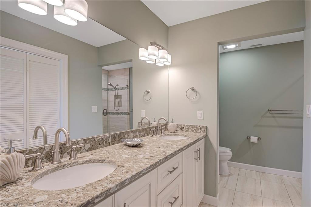 1070 6th Street South, Unit 1070 Naples, FL 34102 - Photo 32 of 41 Full bathroom with double vanity, a shower stall, and a walk-in closet