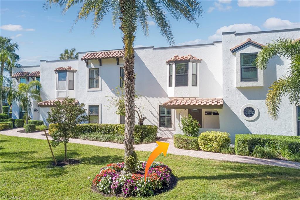 1070 6th Street South, Unit 1070 Naples, FL 34102 - Photo 8 of 41 Mediterranean style - featuring a front manicured yard, covered entry with a tiled roof, and stucco siding