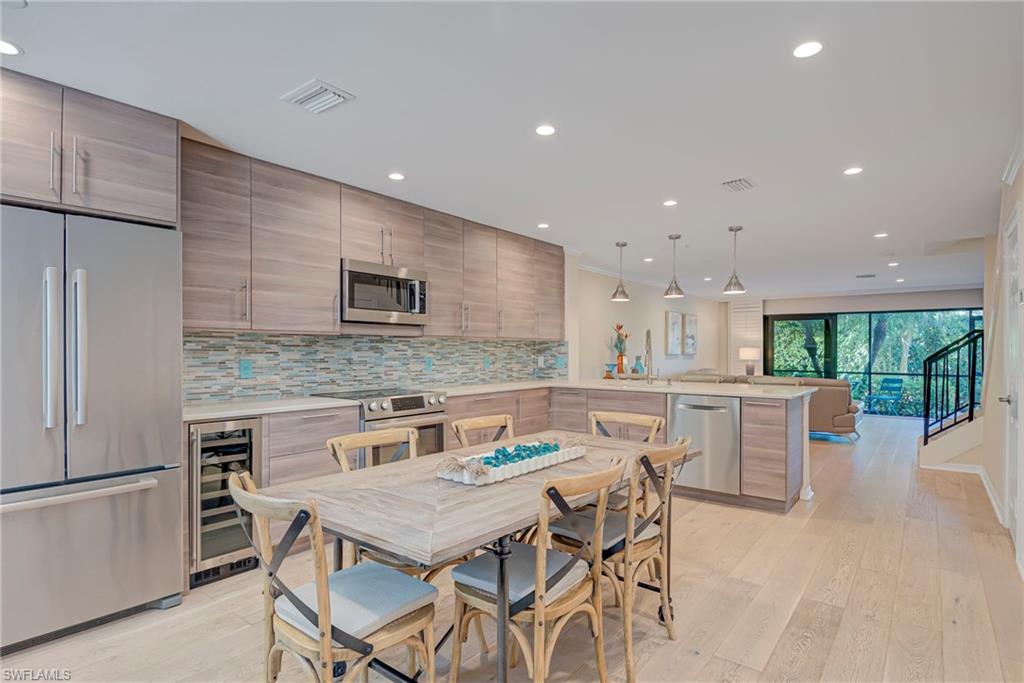 1070 6th Street South, Unit 1070 Naples, FL 34102 - Photo 9 of 41 Kitchen featuring stainless steel appliances, light wood-type flooring, pendant lighting, and modern cabinets.