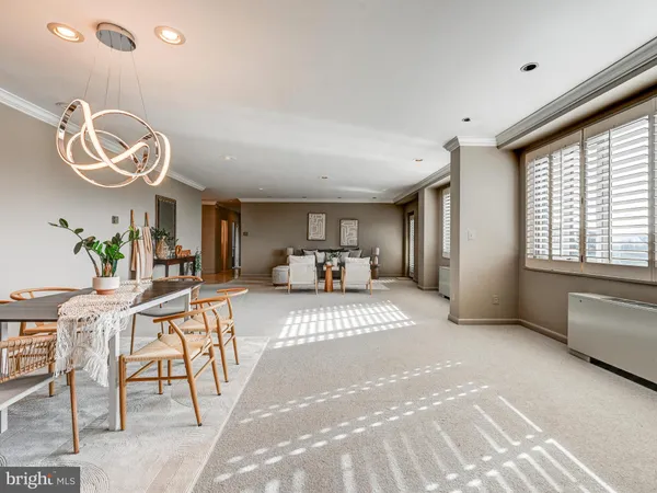 a open kitchen with stainless steel appliances granite countertop a stove top oven a sink a dining table and chairs with wooden floor