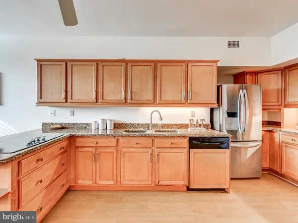 a kitchen with granite countertop a stove top oven microwave and cabinets