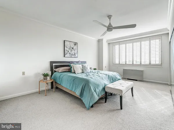 a spacious bedroom with a bed and painting on the wall