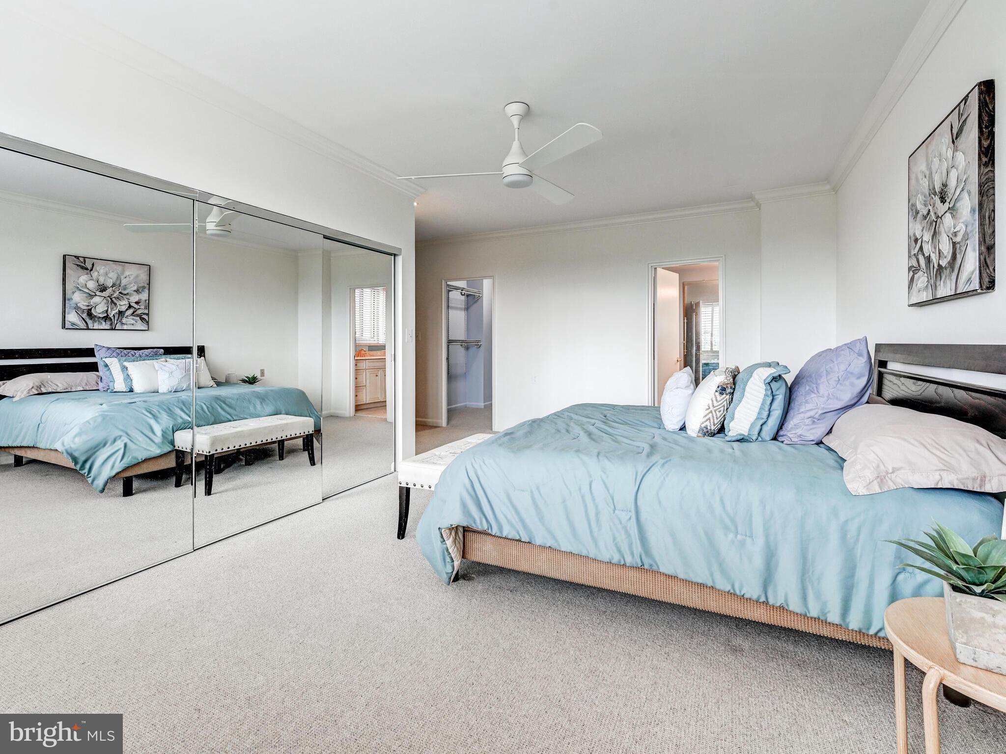 11 Slade Avenue, Unit 912 Baltimore, MD 21208 - Photo 20 of 31 a spacious bedroom with a bed and painting on the wall