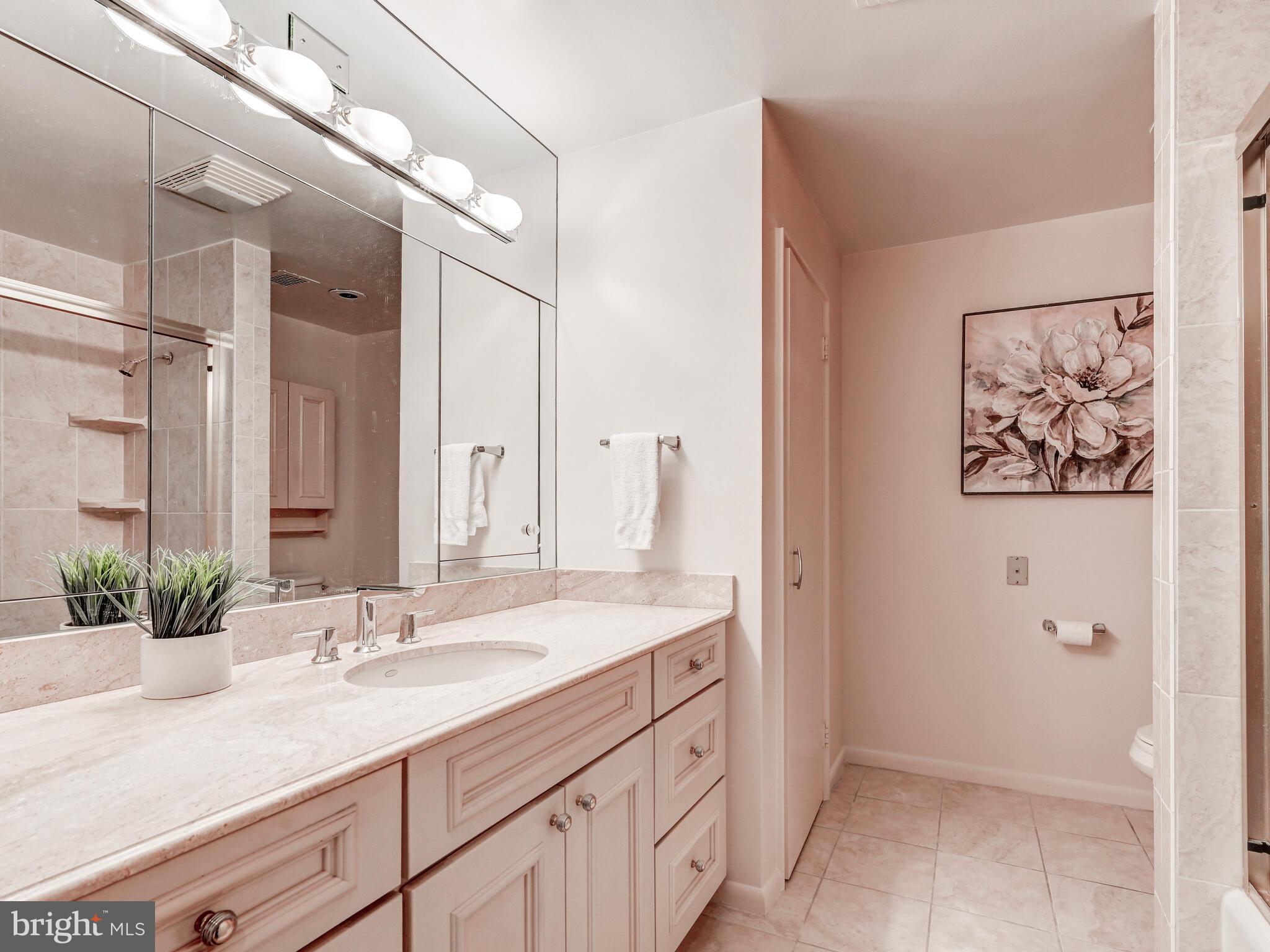 11 Slade Avenue, Unit 912 Baltimore, MD 21208 - Photo 24 of 31 a bathroom with a double vanity sink and a mirror
