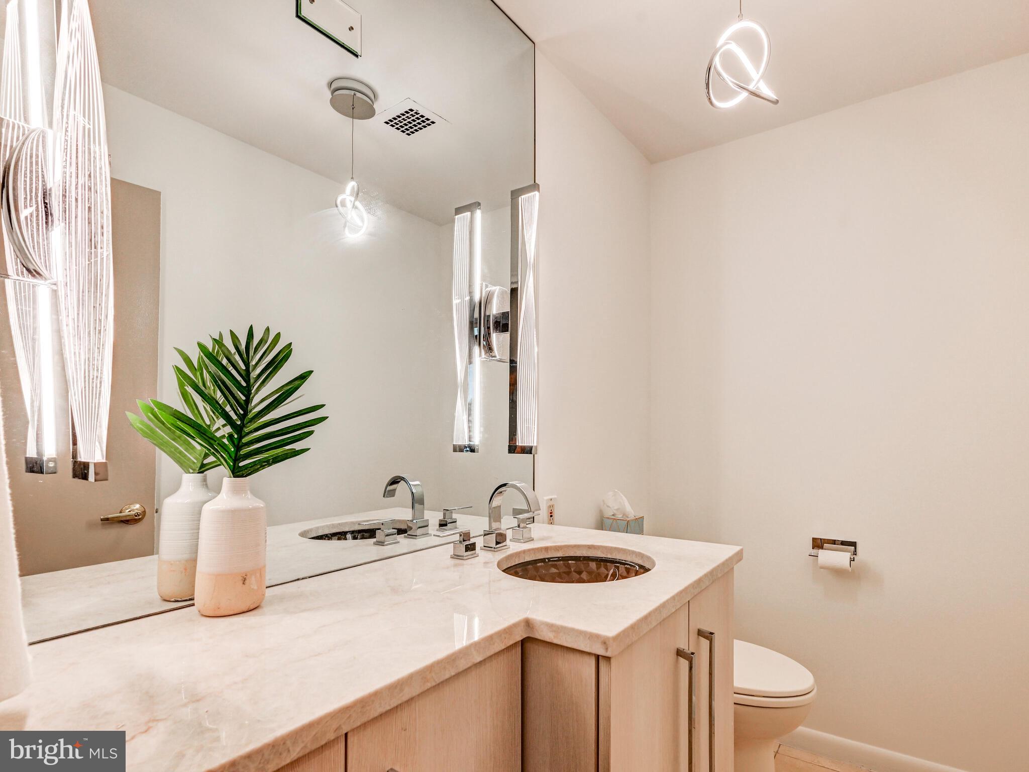 11 Slade Avenue, Unit 912 Baltimore, MD 21208 - Photo 26 of 31 a bathroom with a sink a toilet and a mirror