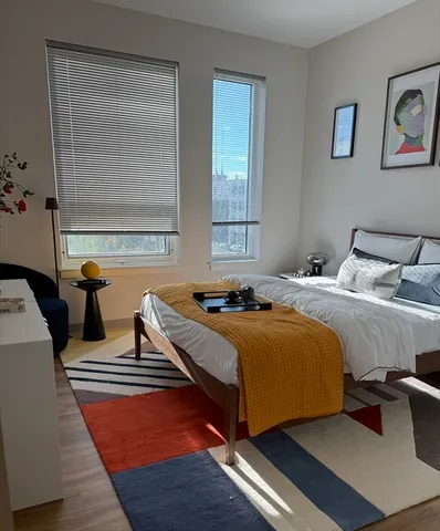 a bedroom with a bed and wooden floor