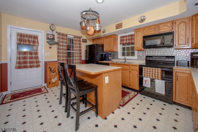 5 Twin Pond Road Montague, NJ 07827 - Photo 10 of 29 a kitchen with stainless steel appliances kitchen island granite countertop a sink a stove a dining table and chairs
