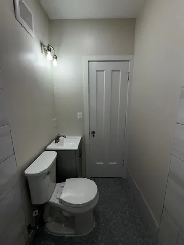 a bathroom with a toilet a sink and mirror