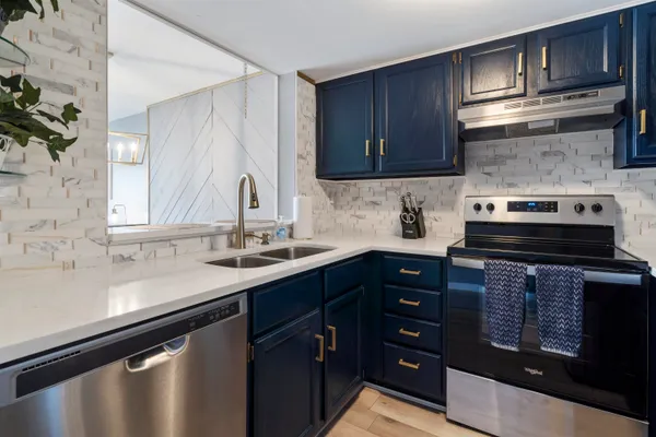 a kitchen with stainless steel appliances granite countertop a sink stove and cabinets