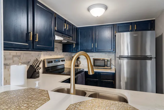 a kitchen with stainless steel appliances granite countertop a refrigerator and a sink