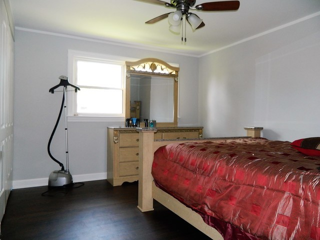 15210 Ridgeway Avenue Midlothian, IL 60445 - Photo 12 of 19 a bedroom with a bed a chandelier and mirror