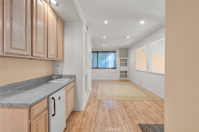 a view of a kitchen with a sink and dishwasher with wooden floor