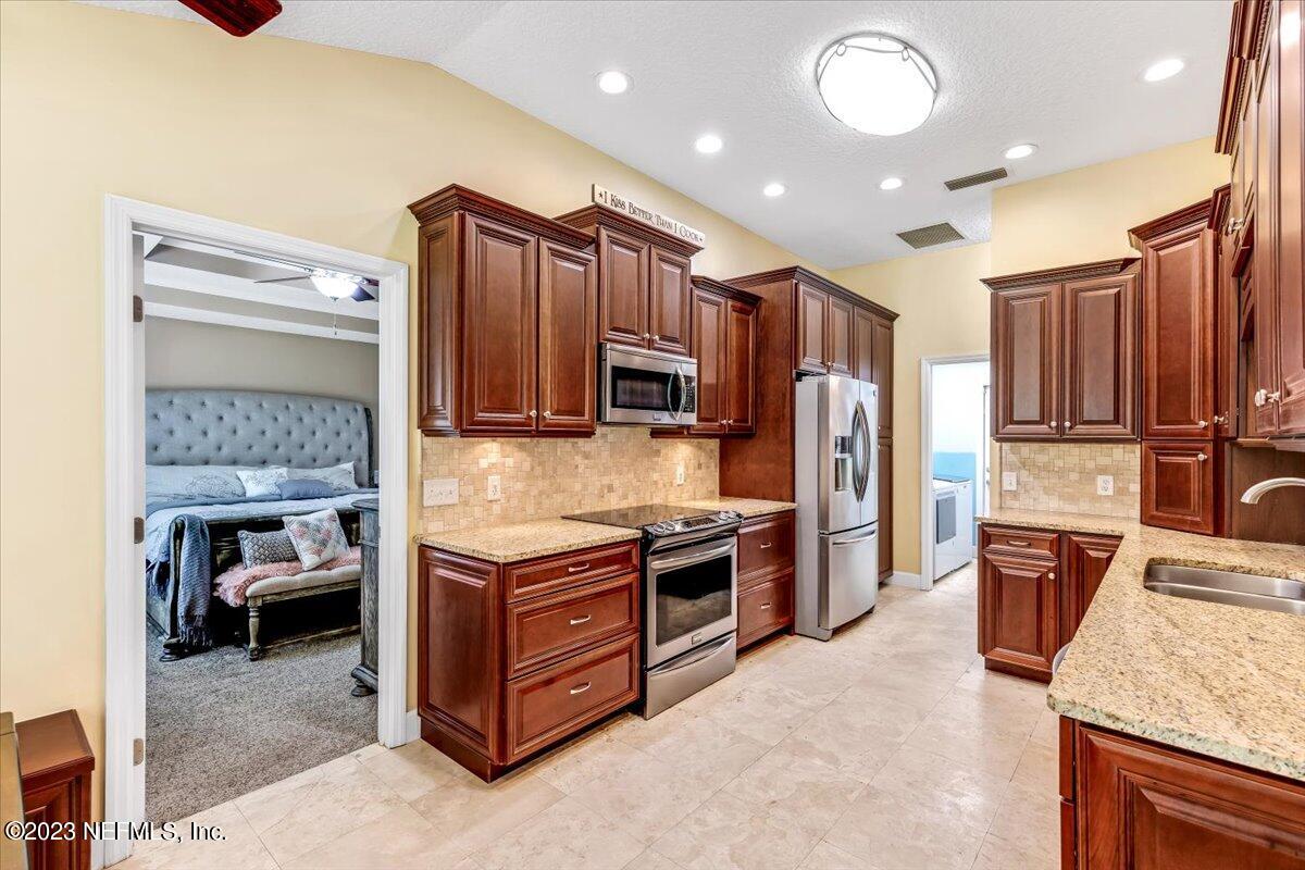 4616 Estates Street Macclenny, FL 32063 - Photo 13 of 32 a kitchen with stainless steel appliances granite countertop a stove refrigerator and cabinets