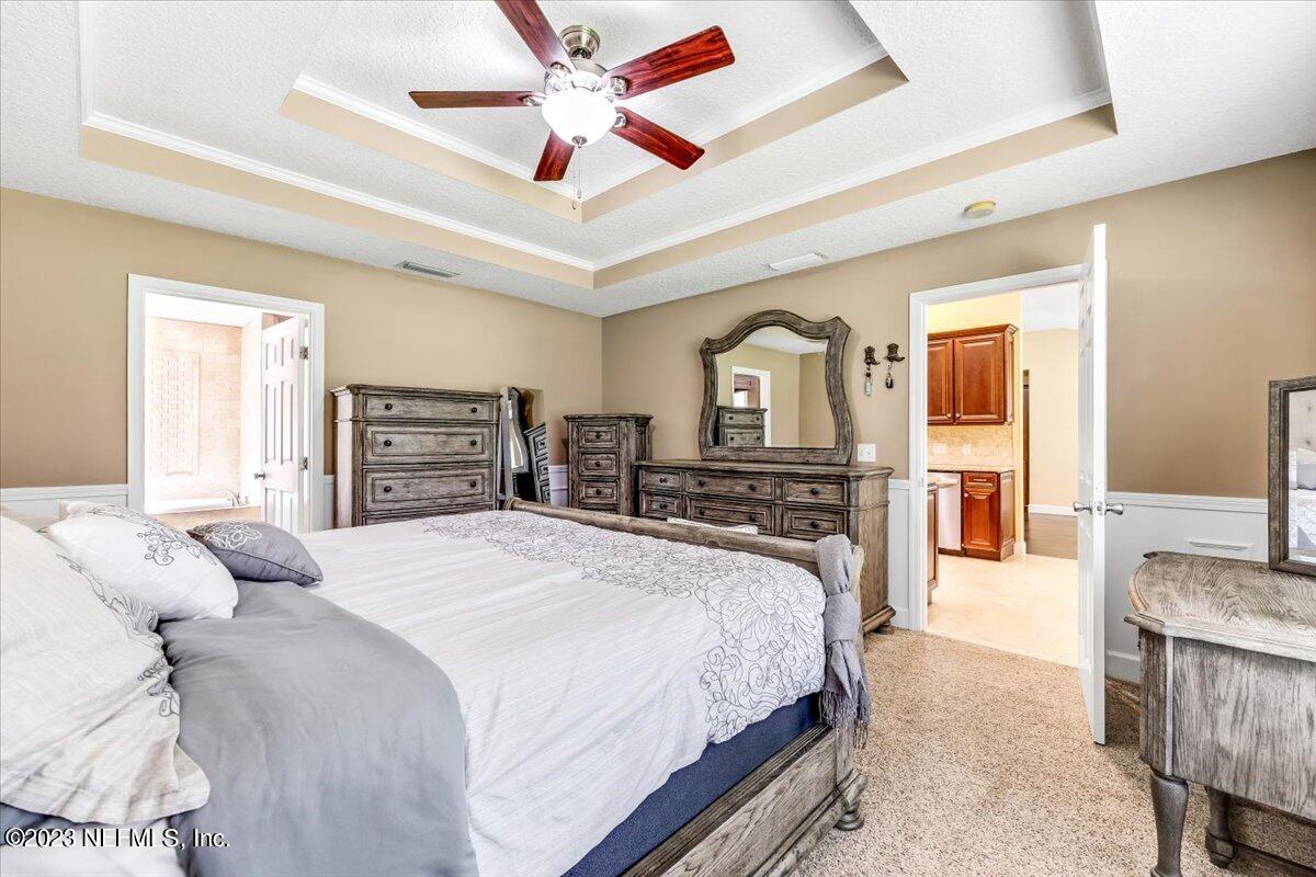 4616 Estates Street Macclenny, FL 32063 - Photo 16 of 32 a bedroom with a large bed a flat screen tv and dresser