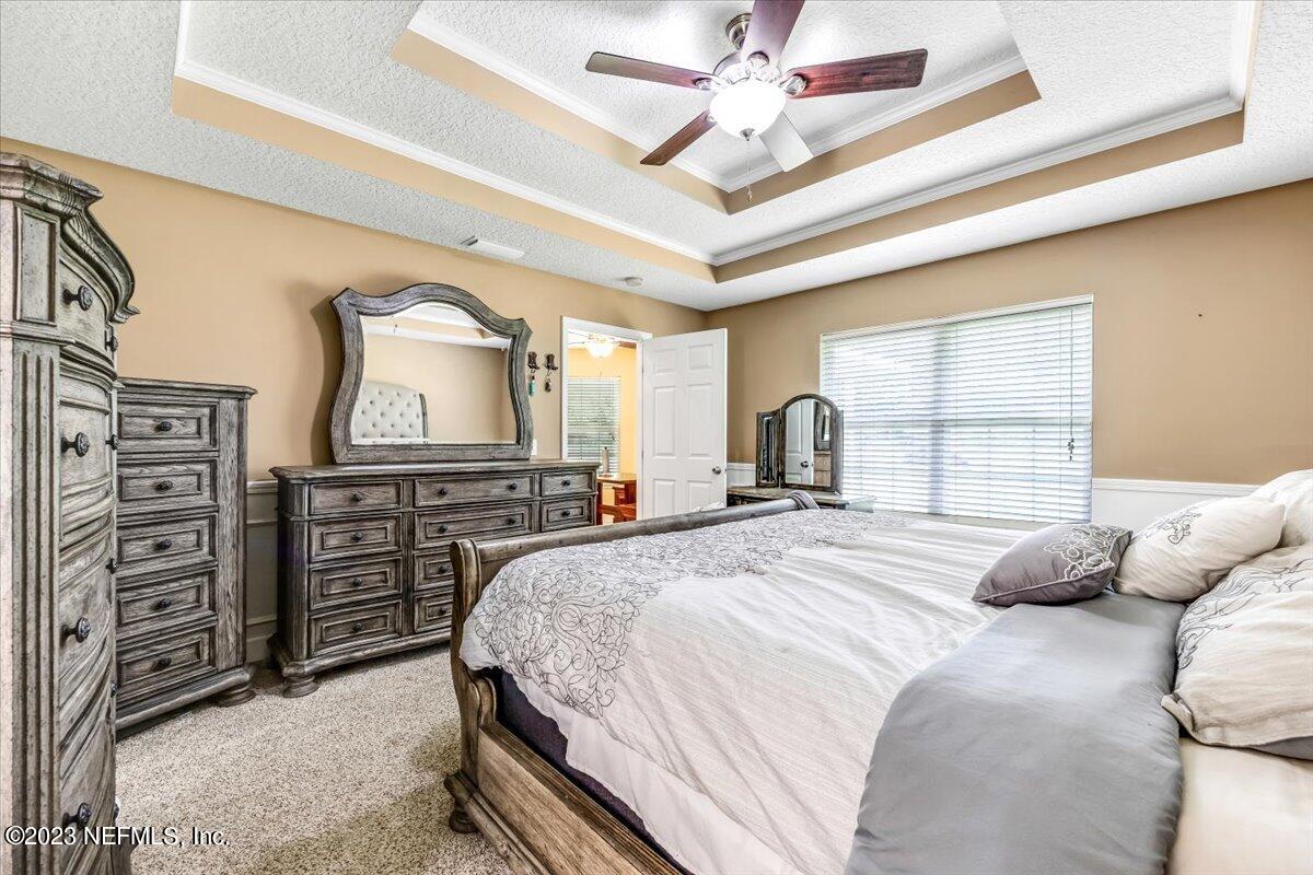 4616 Estates Street Macclenny, FL 32063 - Photo 17 of 32 a bedroom with a bed and a dresser with a large mirror