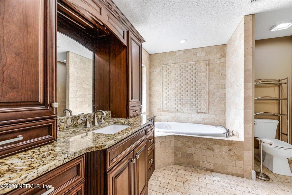 4616 Estates Street Macclenny, FL 32063 - Photo 18 of 32 a bathroom with a granite countertop sink and a bathtub