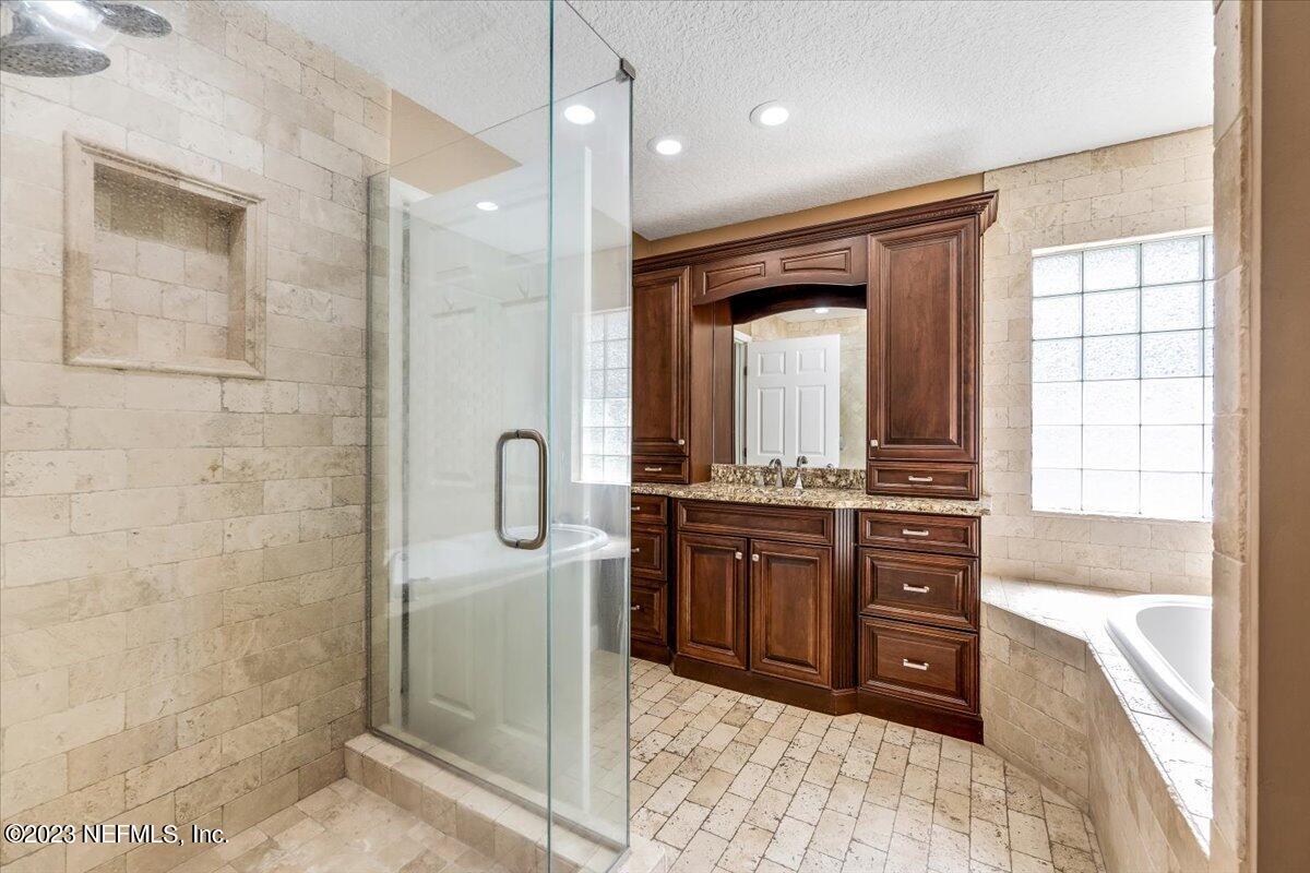 4616 Estates Street Macclenny, FL 32063 - Photo 20 of 32 a bathroom with a granite countertop sink mirror and shower