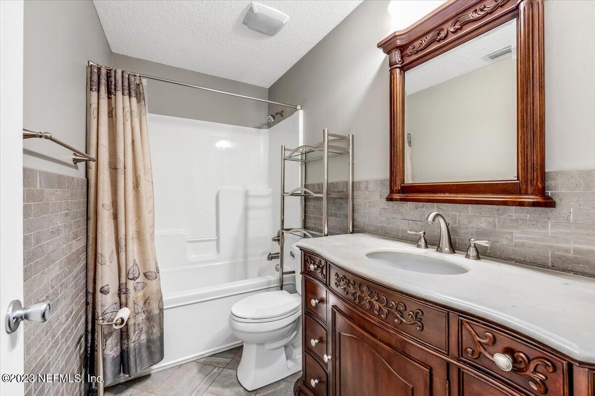 4616 Estates Street Macclenny, FL 32063 - Photo 26 of 32 a bathroom with a sink a toilet a mirror and shower