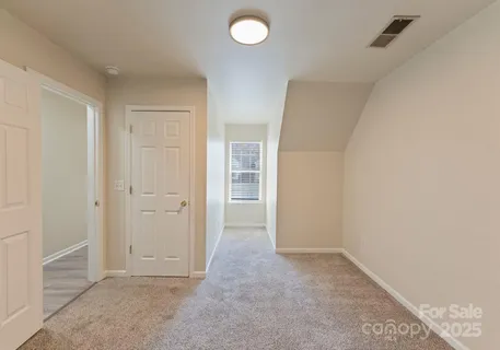 an empty room with closet and windows