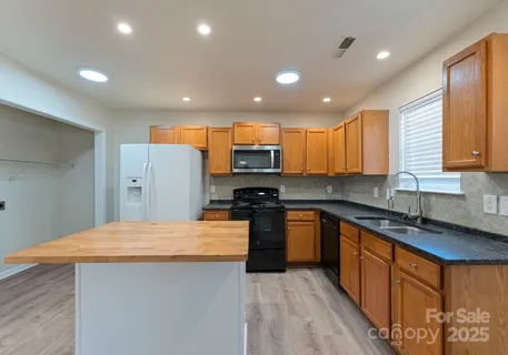 a kitchen with stainless steel appliances granite countertop a sink stove and refrigerator