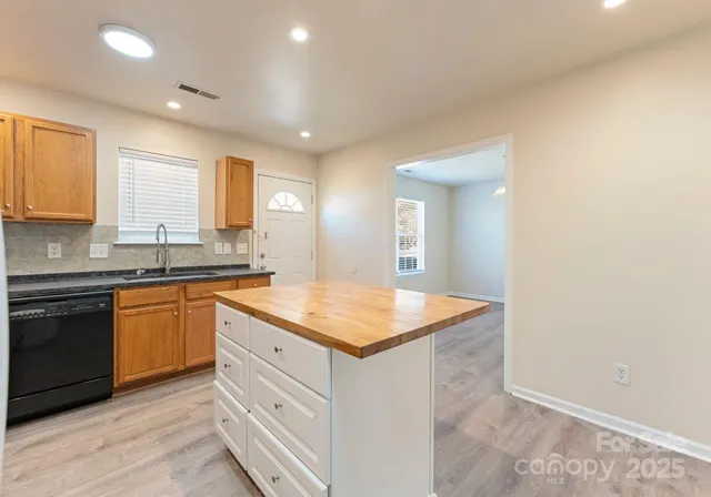 a kitchen with granite countertop white cabinets and white appliances