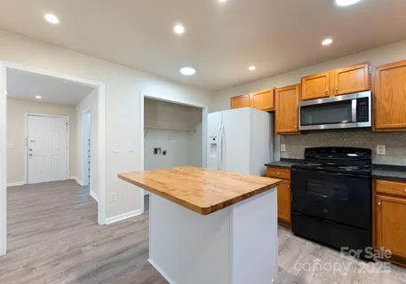 a kitchen with stainless steel appliances a stove refrigerator and microwave