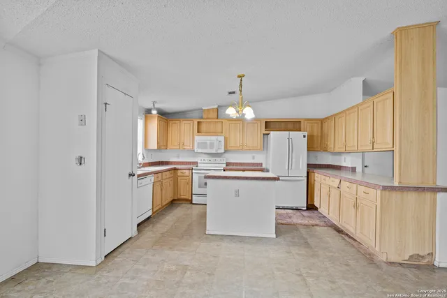 a kitchen with a refrigerator and white cabinets