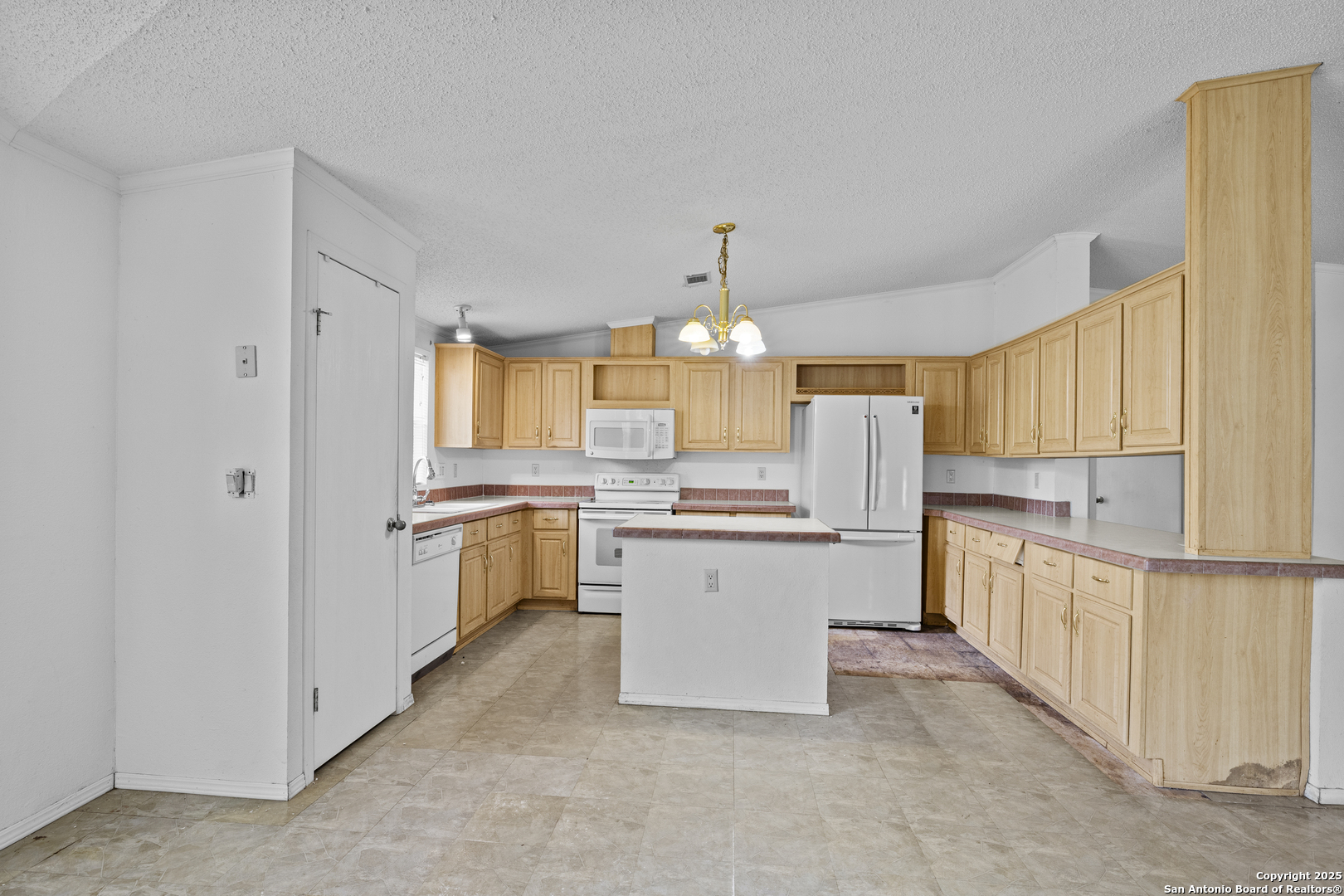 1189 Vivroux Ranch Road Seguin, TX 78155 - Photo 6 of 24 a kitchen with a refrigerator and white cabinets