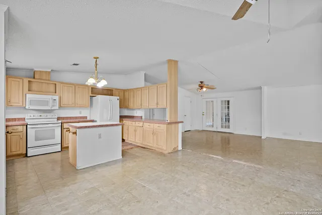 a large white kitchen with cabinets a sink and a stove