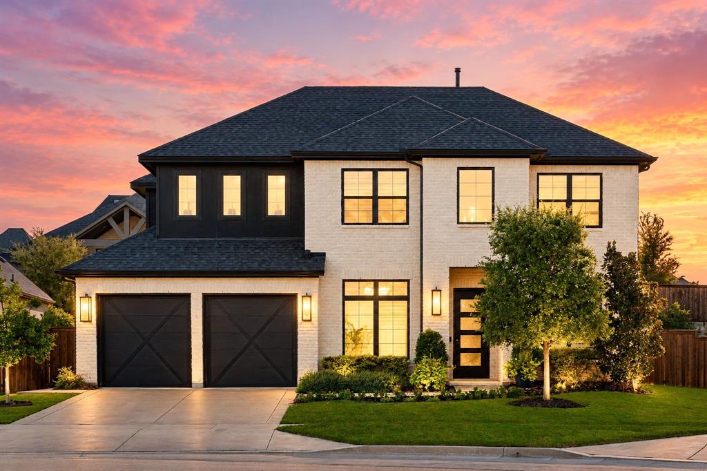 8408 Twistpine Road Frisco, TX 75035 - Photo 31 of 38 White brick exterior with dark trim, dual garage doors with X-detail, black framed windows, and exterior lighting fixtures