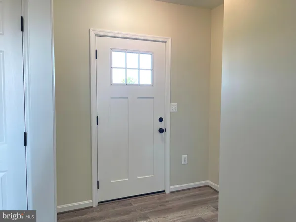 a view of an empty room with wooden floor and closet