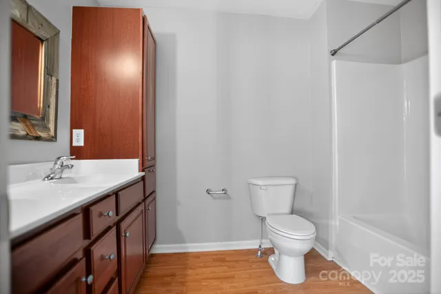 a bathroom with a granite countertop sink toilet and a mirror