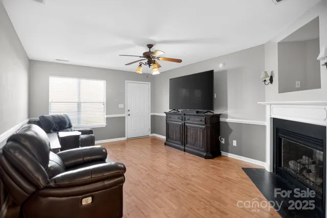 a living room with furniture a fireplace and a flat screen tv