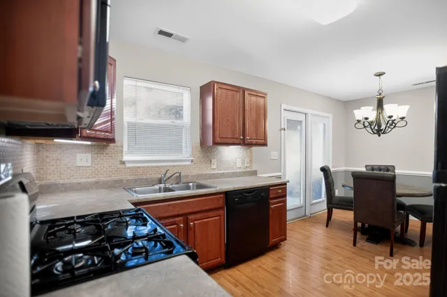 a kitchen with stainless steel appliances a sink stove and cabinets