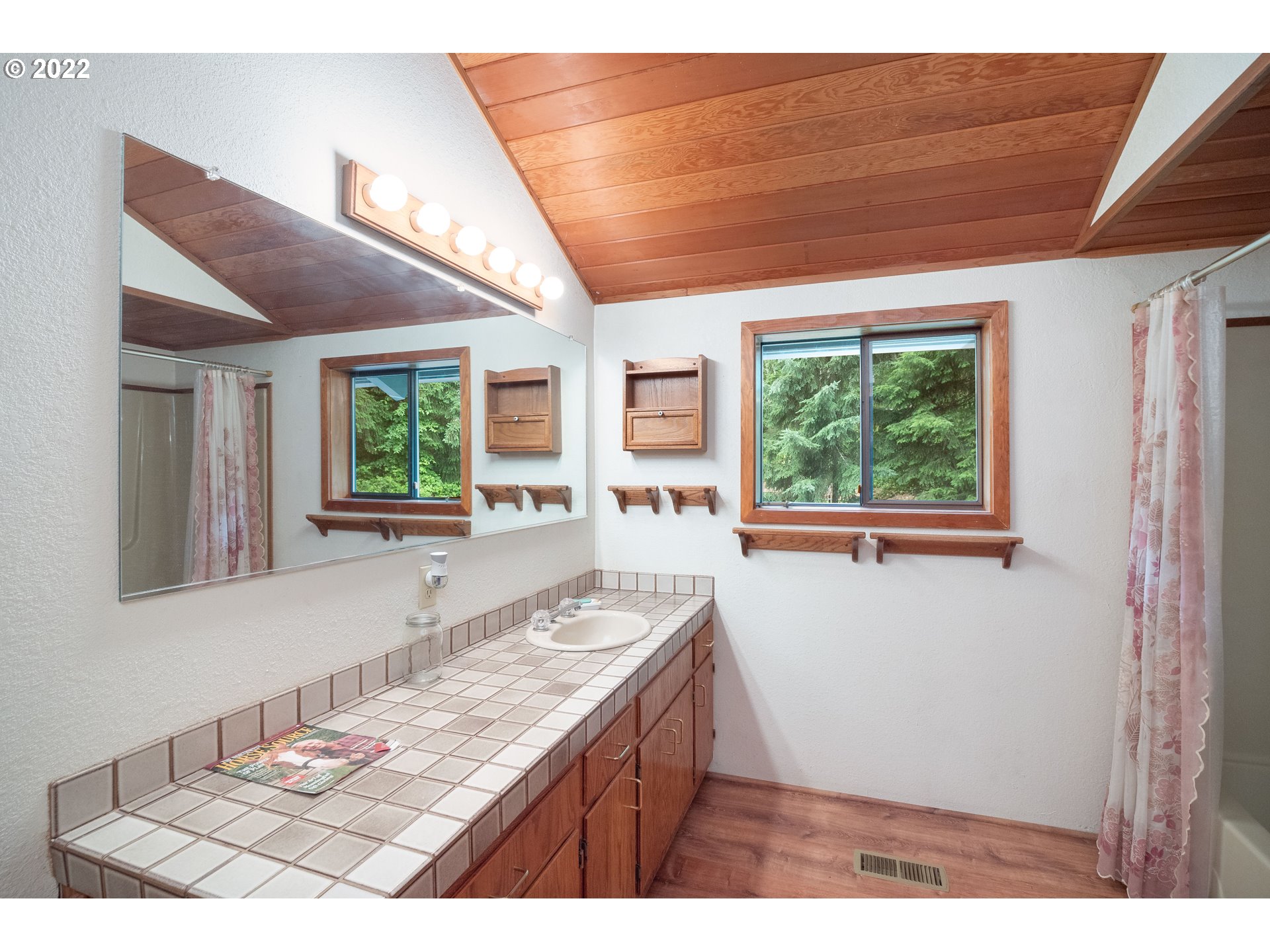378 Racoon Road Oakland, OR 97462 - Photo 17 of 32 a bathroom with a granite countertop sink and a large mirror