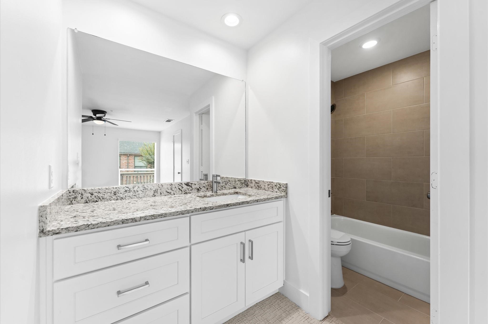 2829 Timmons Lane, Unit 202 Houston, TX 77027 - Photo 12 of 17 a bathroom with a granite countertop sink a toilet and bathtub