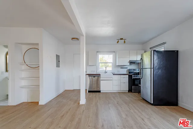 a kitchen with a refrigerator and a stove top oven