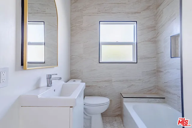 a bathroom with a sink a toilet and window