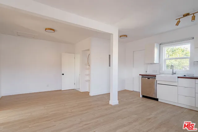 a view of a kitchen with a sink dishwasher and wooden floor