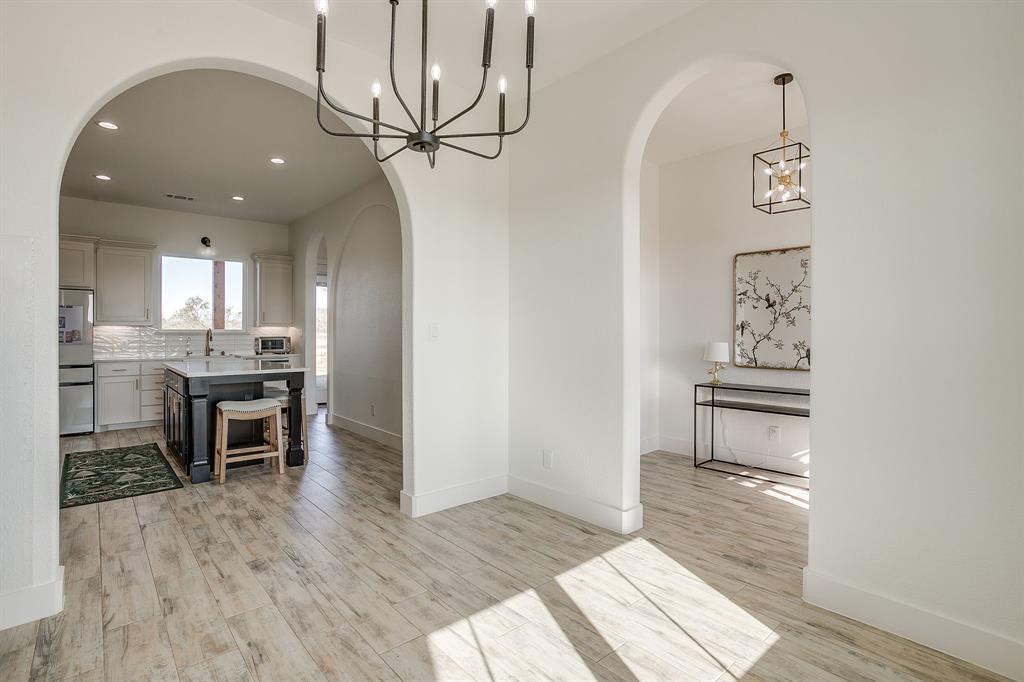 8140 Lavender Road Springtown, TX 76082 - Photo 12 of 40 a view of a hallway with wooden floor windows and a kitchen view