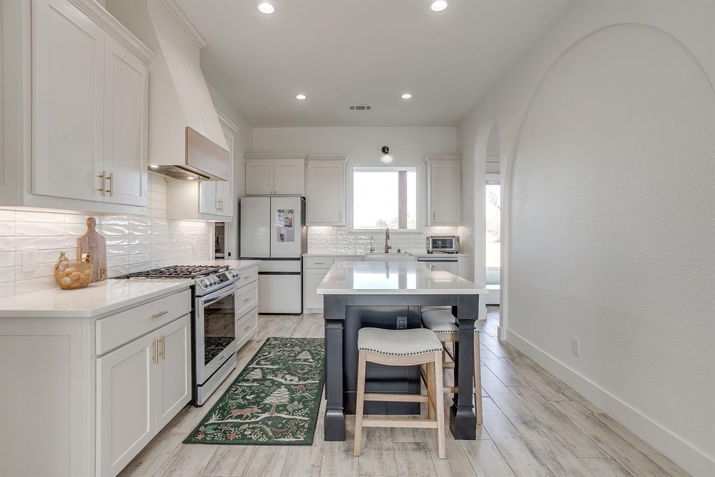 8140 Lavender Road Springtown, TX 76082 - Photo 16 of 40 a kitchen with stainless steel appliances granite countertop a sink stove and refrigerator
