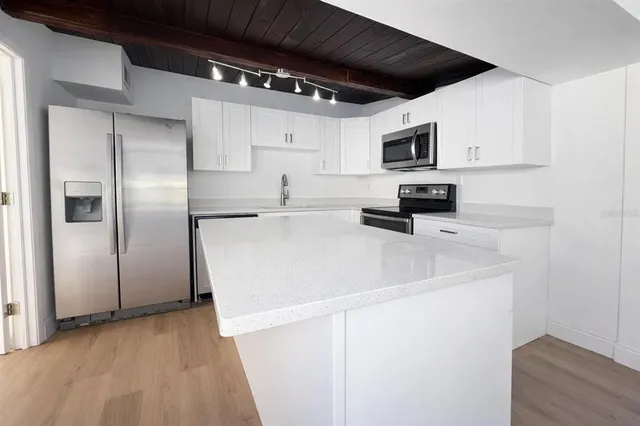 a kitchen with stainless steel appliances a refrigerator sink and microwave