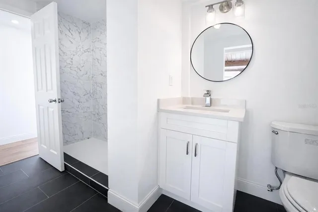 a bathroom with a sink a toilet and a mirror