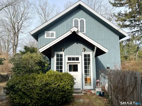 a front view of a house with a yard and potted plants