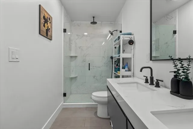 a bathroom with a sink a toilet and shower