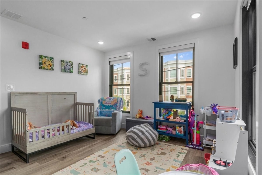 173 Magnolia Street, Unit 5 Boston, MA 02125 - Photo 16 of 23 a bedroom with furniture and a wooden floor